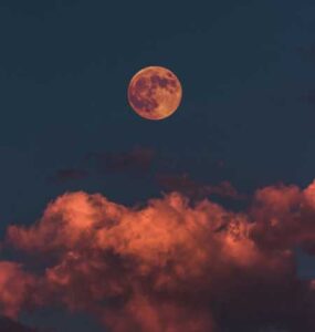 Photo of a full moon at sunset.