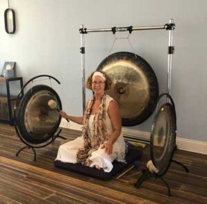Photo of Adele Giotta with gong in her studio.