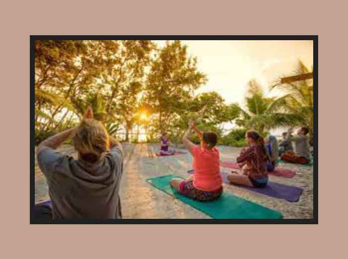 Photo of yoga prctitioners on the beach at sunset.